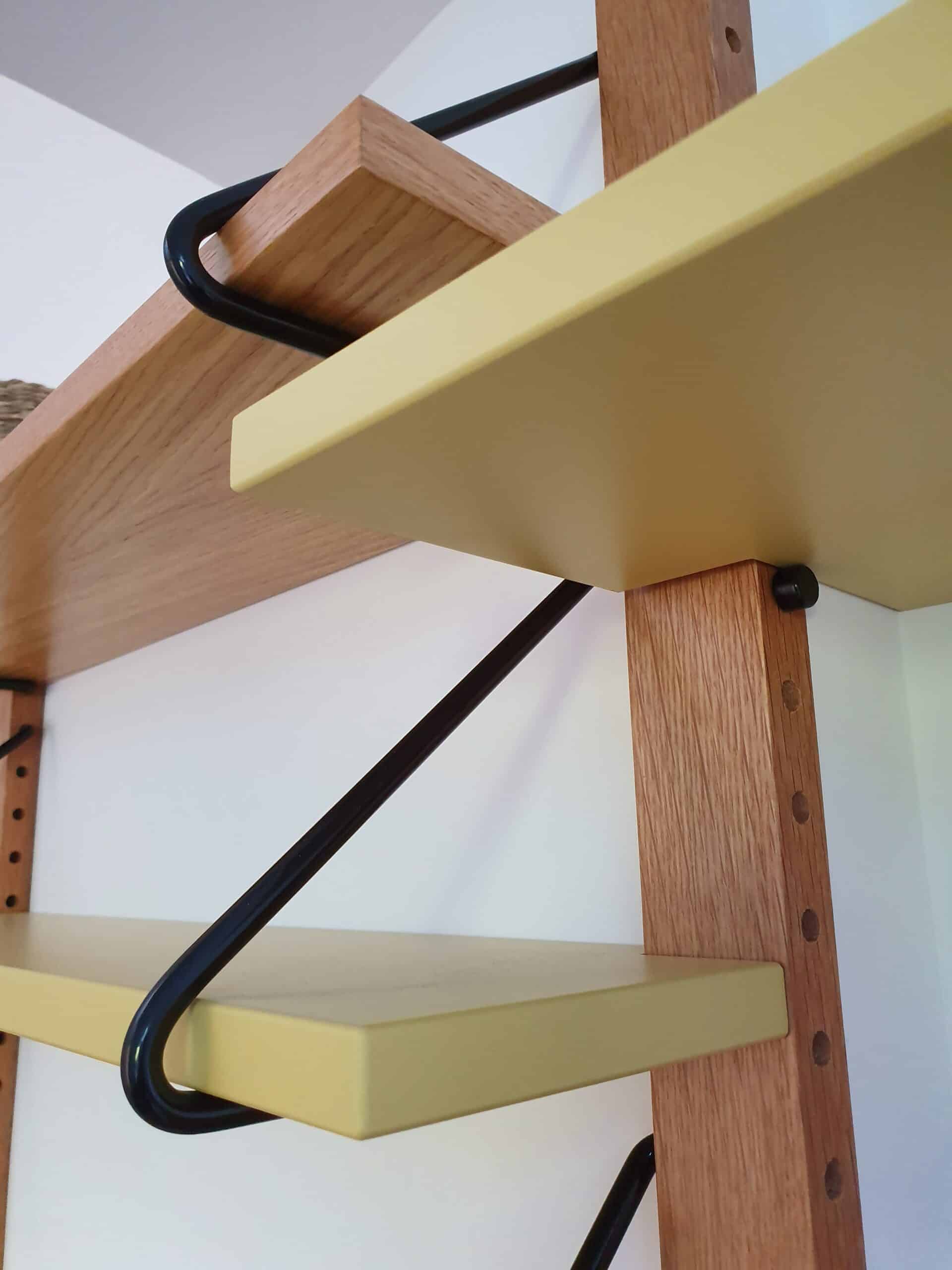 Étagère murale modulable avec montants en bois et tablettes jaunes au style minimaliste.