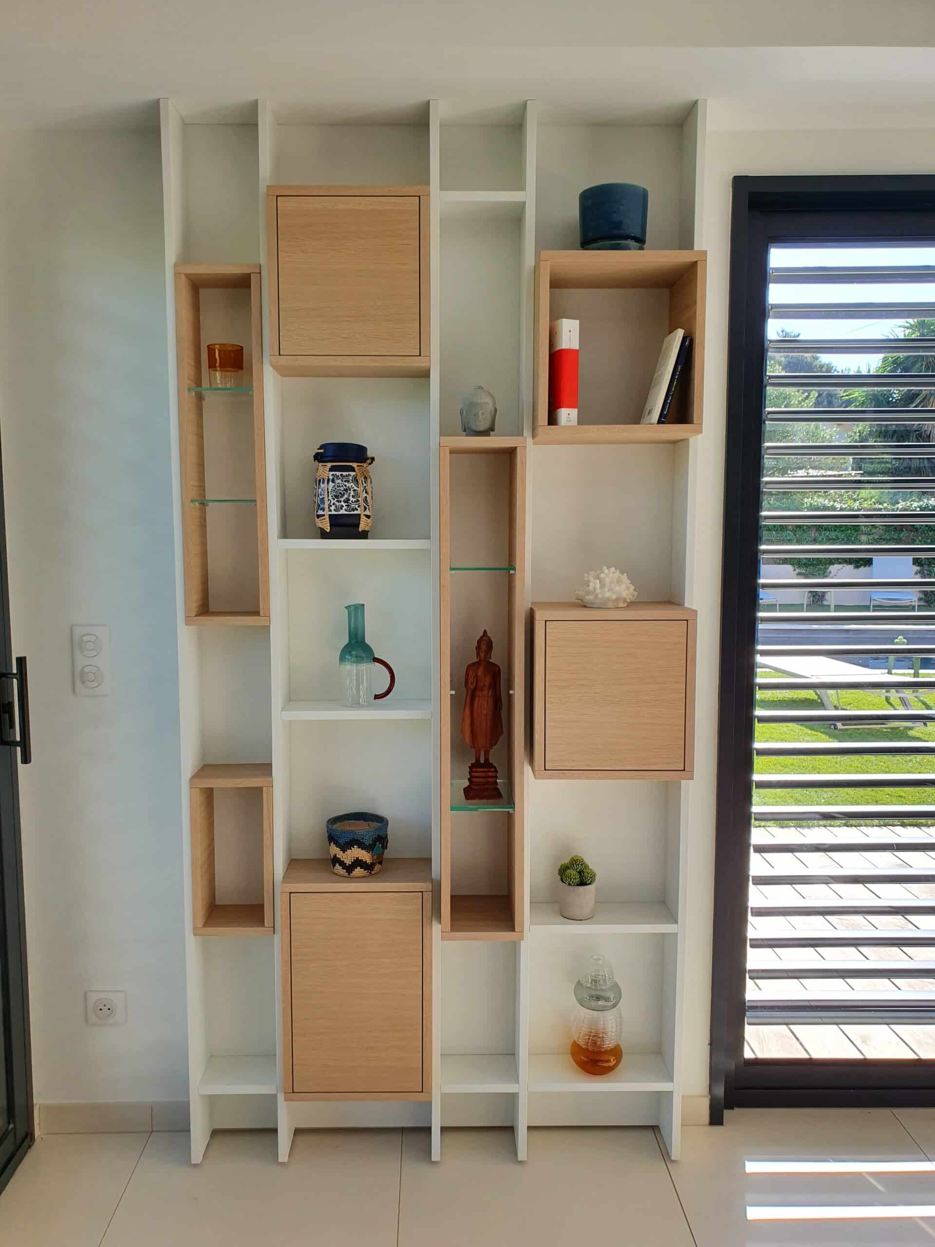Étagère murale moderne blanche et bois avec objets déco et figurines dans un intérieur lumineux.