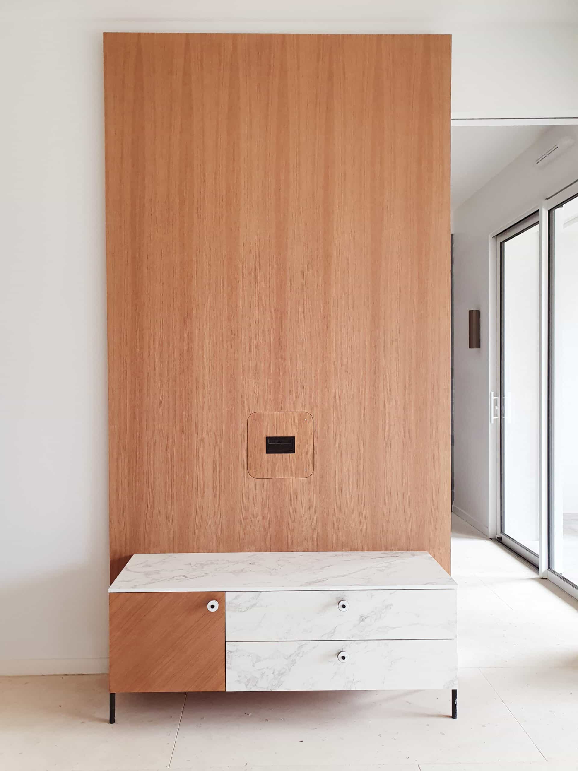 Meuble TV moderne marbre et bois, grand panneau mural en chêne clair et design minimaliste.